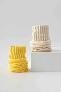 Detailaufnahme von weichen gerippten Socken in leuchtendem Gelb und neutralem Beige.
