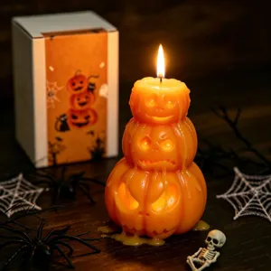 Gros plan détaillé d'une bougie parfumée d'Halloween en forme de citrouilles empilées avec visage.