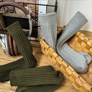 Detailed shot of solid color ribbed crew socks in cozy lifestyle setting, soft cotton knit.