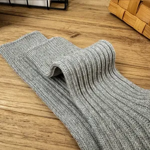 Grey knit socks detail view, thick ribbed ribbed fabric, comfortable winter fashion accessory.