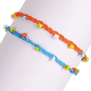 Macro detail showing handmade colorful bead and wax thread braiding on bohemian anklet
