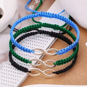 Detailed close-up showing the silver infinity charm on handmade woven friendship bracelets