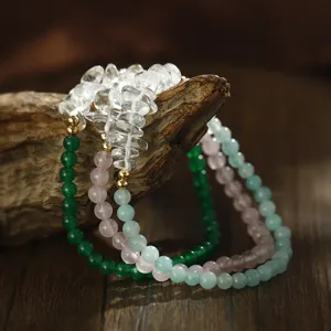 Detailansicht von Naturstein- und Perlenarmbändern auf einem verwitterten Vintage-Holzstück