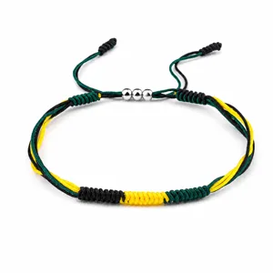 Close-up of handmade braided friendship bracelet with Jamaica flag color scheme