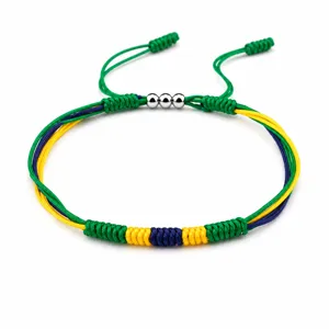 Close-up of handmade braided friendship bracelet in flag colors with three copper beads