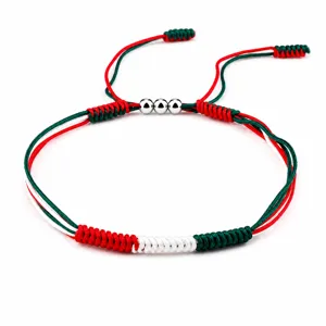 Macro detailed view of a hand-woven flag color bracelet with three silver metallic beads