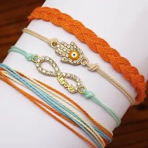 Vista dettagliata del set di bracciali bohémien in cordoncino di cera con occhio di Hamsa