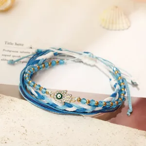 Dettaglio di bracciali bohémien in filo cerato con ciondolo mano di Fatima e perle di cristallo