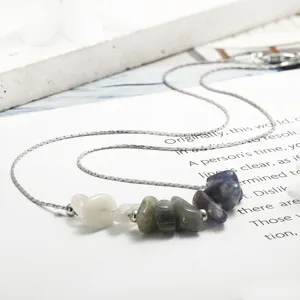 Detailed macro view of natural raw kyanite and amethyst stones on a silver chain.