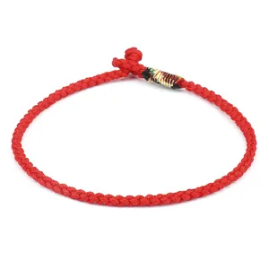 Close-up detail of a minimalist hand-braided red rope bracelet with colorful thread