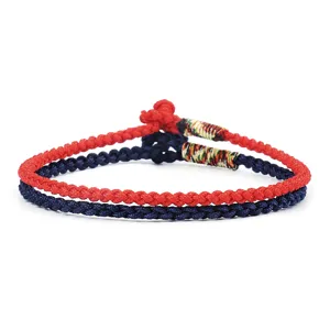 Detailed view of hand-woven red and navy blue cord bracelets with decorative knots