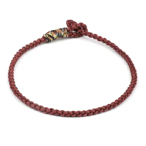 Close-up detail of a handmade brown woven rope bracelet with multicolored accent threads