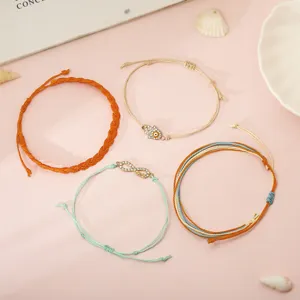 Dettaglio del set di bracciali bohémien in cordino di cera con malocchio e ciondoli infinito