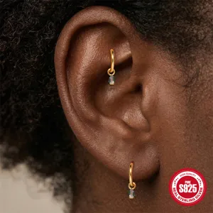 Macro detail of 925 sterling silver gold hoop earrings with natural moss agate drops