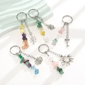 Detailed macro view of natural crushed stone keychains featuring sun leaf and key charms.