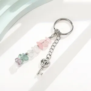 Close-up of crystal stone bead keychain with vintage key pendant and triskele symbol