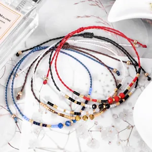 Primo piano di braccialetti intrecciati con perline colorate e cordino regolabile