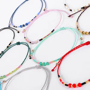 Vista dettagliata di braccialetti intrecciati a mano colorati con accenti di perline