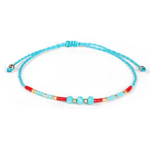 Dettaglio di un braccialetto intrecciato blu con perline rosse e blu e oro lucido