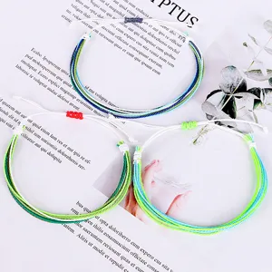 Primer plano de un juego de tres coloridas pulseras de playa de cuerda trenzada ajustable