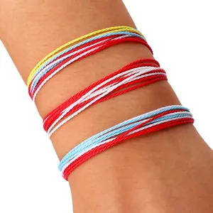 Primer plano de tres juegos de pulseras ajustables de hilo de cera trenzado de colores