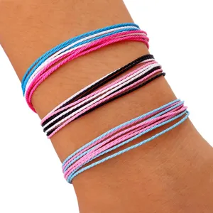 Primer plano de tres pulseras de hilo de cera trenzado impermeable de colores vivos