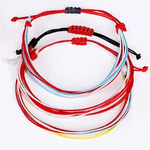 Primer plano de tres pulseras tejidas de cordón de cera coloridas e impermeables