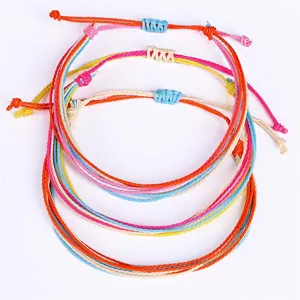 Vista detallada de tres pulseras ajustables de hilo de cera trenzado de colores.