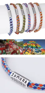 Close-up of colorful braided cotton bracelets with engraved Six-Syllable Mantra metal beads