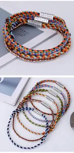 Detailed view of handmade colorful braided cotton bracelets with mantra engraved tubes