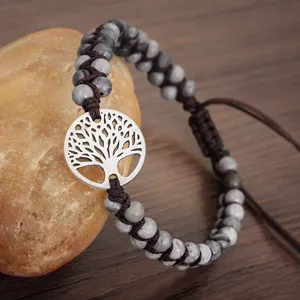 Détail d'un bracelet en perles tissé à la main avec un charme arbre de vie.