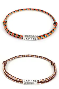 Detail view of two braided cotton bracelets featuring engraved Six-Syllable Mantra charms