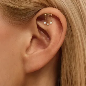 Detaillierte Nahaufnahme des vergoldeten S925 Silber Helix-Piercings mit Stern-Quasten