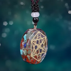 Primer plano de colgante de resina con cristales y patrón de geometría sagrada