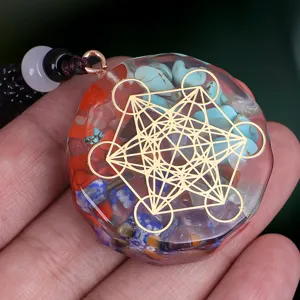 Close-up of resin orgone pendant with colorful crushed stones and gold Metatron's Cube
