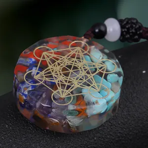 Detailed close-up of a resin pendant with crushed crystals and golden Metatron's Cube symbol.