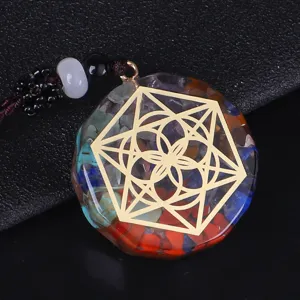 Primer plano de un colgante de orgonita hexagonal con cristales y un mandala dorado