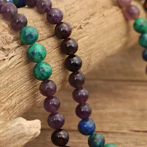 Dettaglio della collana con 108 grani mala in ametista e granito su legno naturale