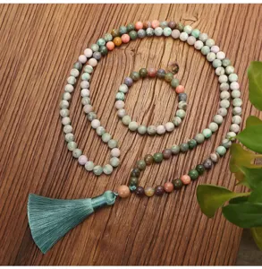 Detail van een lange 108 Indiase agaat mala kralen ketting met een decoratieve groene kwast