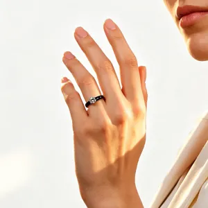 Nahaufnahme eines eleganten schwarzen Emaille-Rings mit Zirkonia an der Frauenhand