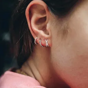 Detailed macro view of 925 sterling silver criss-cross zircon ear cuff on ear model