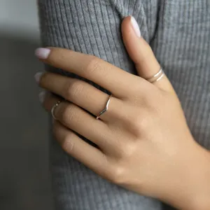 Primo piano di un anello minimalista in argento sterling a forma di V sulla mano
