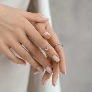 Primo piano di un anello minimalista in argento sterling 925 a forma di V su un dito.