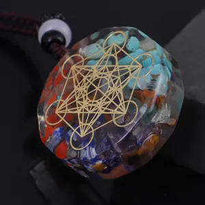 Macro view of orgonite resin pendant with colorful crystal stones and gold Metatron's Cube