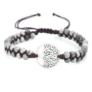 Détail d'un bracelet en perles de pierre de carte tissé avec un charme d'arbre de vie