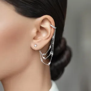 Detailed view of sterling silver ear cuff with sparkling zircon tassel chains on ear.