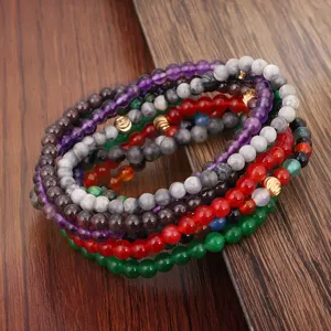 Makroansicht von 4mm mehrfarbigen Steinarmbändern mit Kupferperlen auf Holzhintergrund