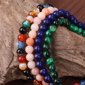 Nahaufnahme von 4 mm bunten Naturstein-Perlenarmbändern auf natürlichem Holzhintergrund