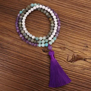 Collar Mala de 108 piedras naturales con borla morada sobre fondo de madera rústica