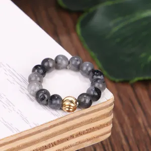 Makroaufnahme eines 4mm Labradorit-Perlenrings mit goldener strukturierter Metallperle